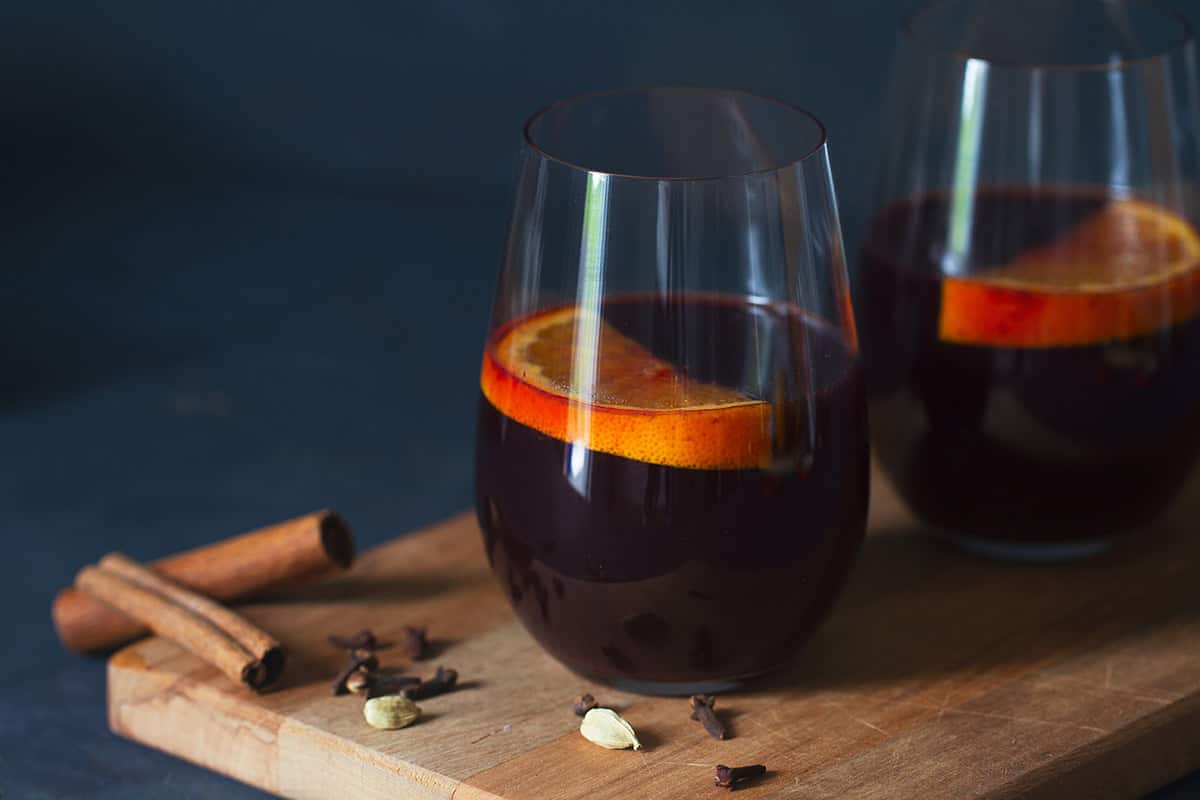 Two glasses of mulled wine on a wooden board.