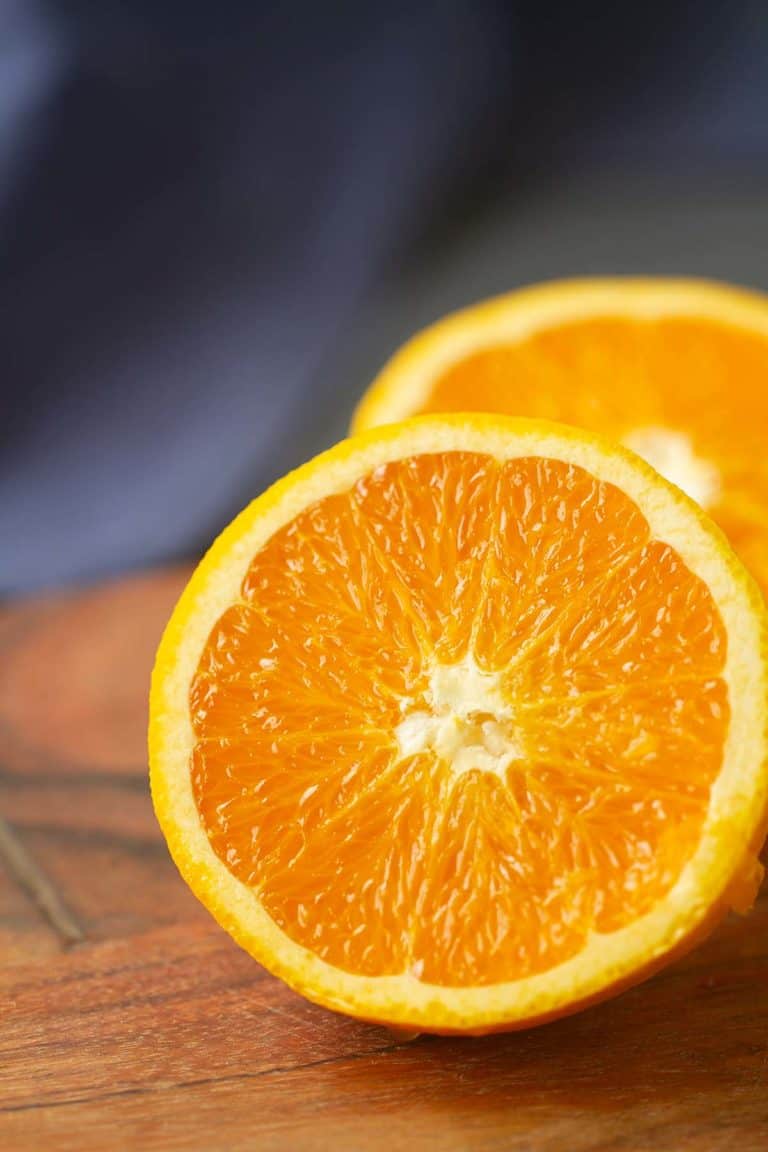 Close-up of half an orange on a wooden board.