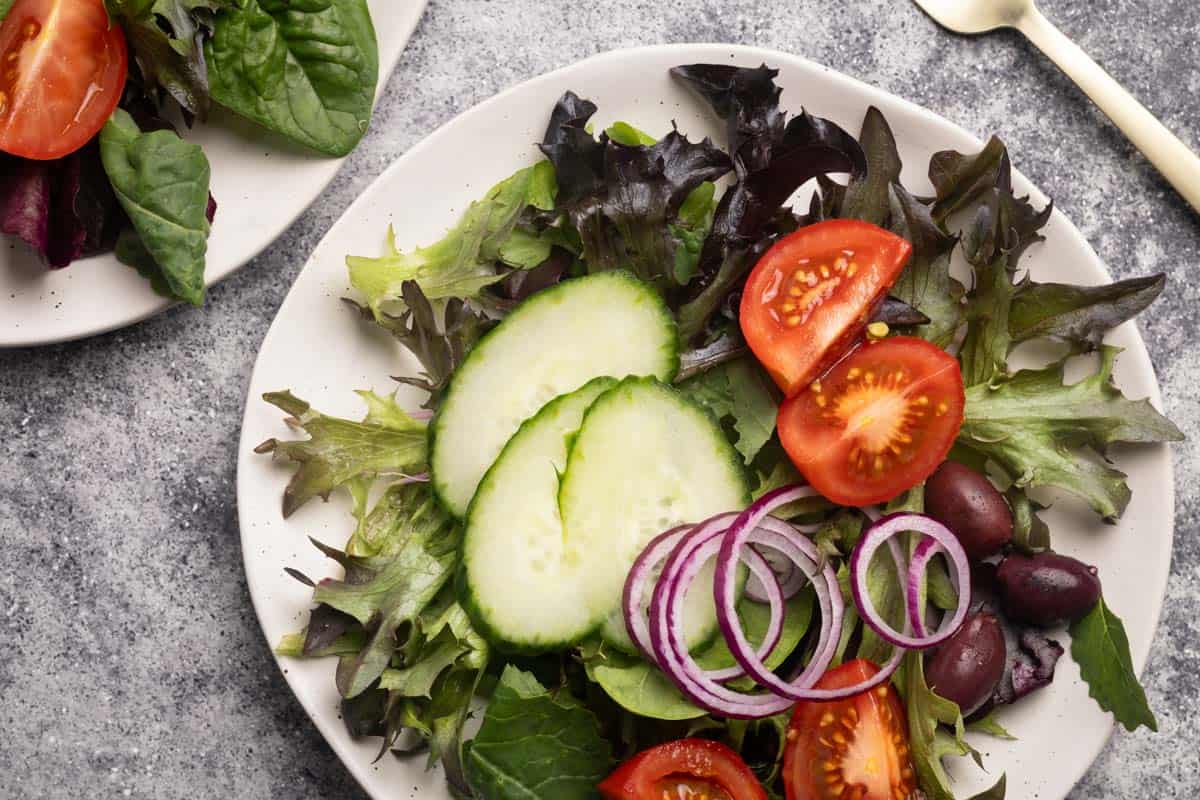 Mixed salads on small white side plates.