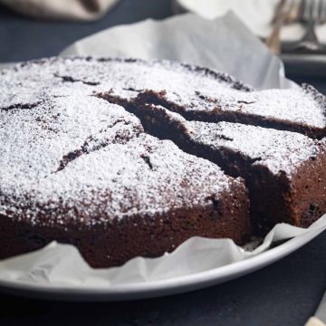 A sliced Schokokuchen on a plate. Plates in the back.