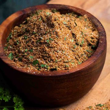 Chermoula spice blend in a wooden bowl which sits on a wooden board.