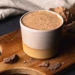 A cup of ceremonial cacao on a wooden board.
