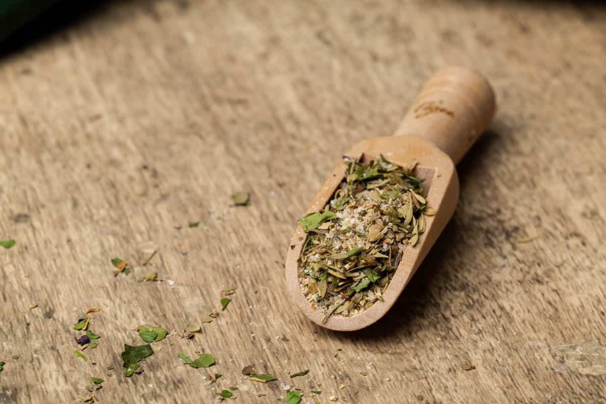 A wooden spoon filled with mediterranean seasoning.