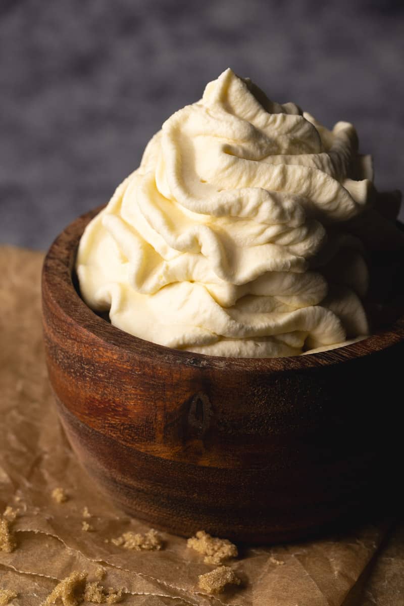 A wooden bowl filled with brown sugar whipped cream.
