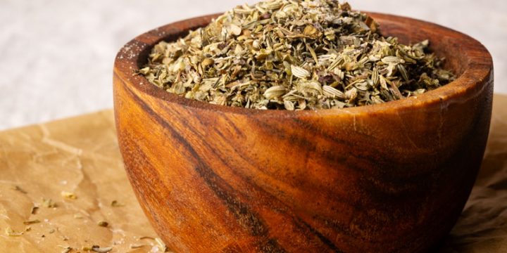 A wooden bowl filled with homemade Tuscan seasoning.
