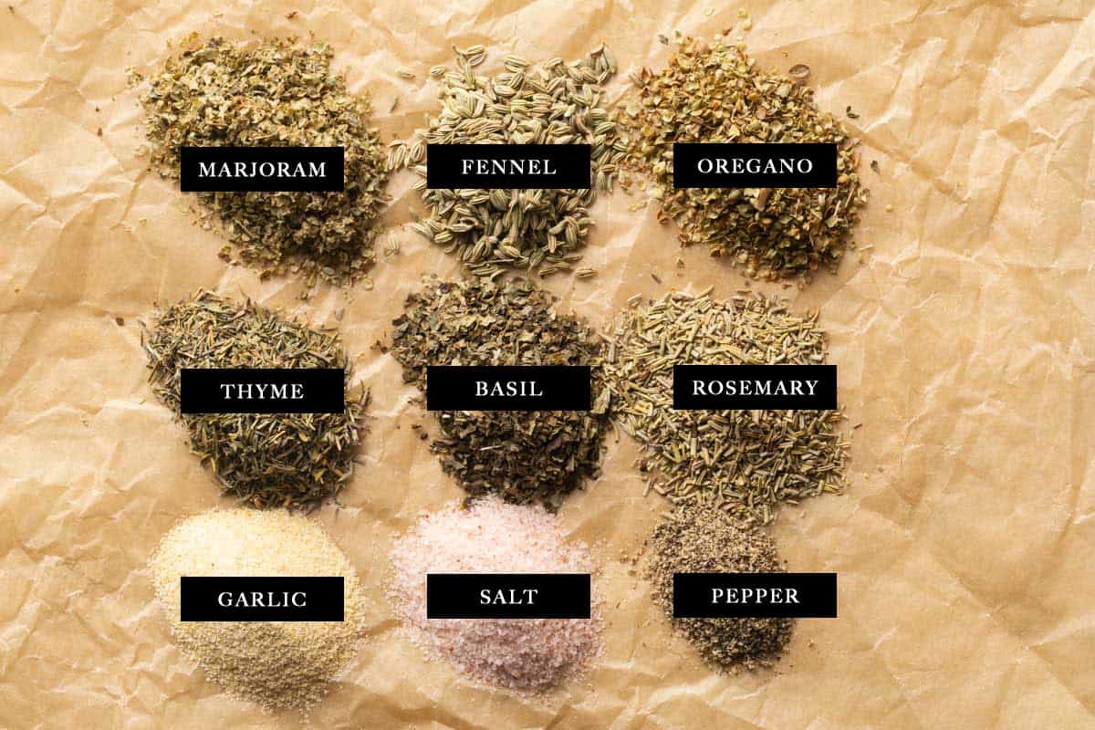 Tuscan seasoning ingredients laid out on parchment paper.
