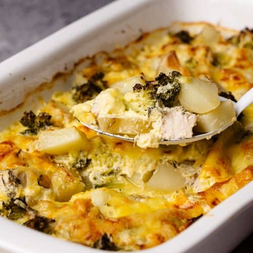 Chicken Potato Casserole being scooped out of a white casserole dish.