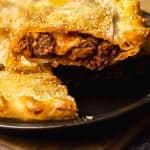 A slice of ground beef pie being lifted from the pie dish.