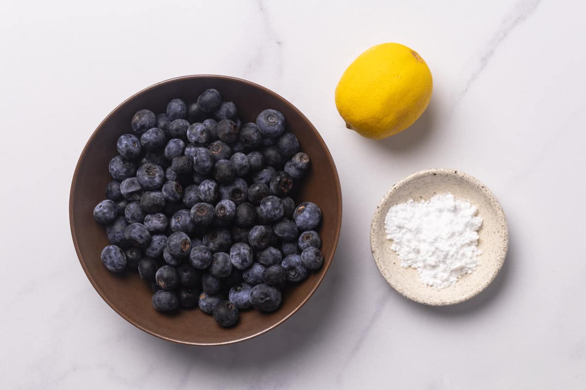Macerated blueberries in a brown bowl which is sitting o
