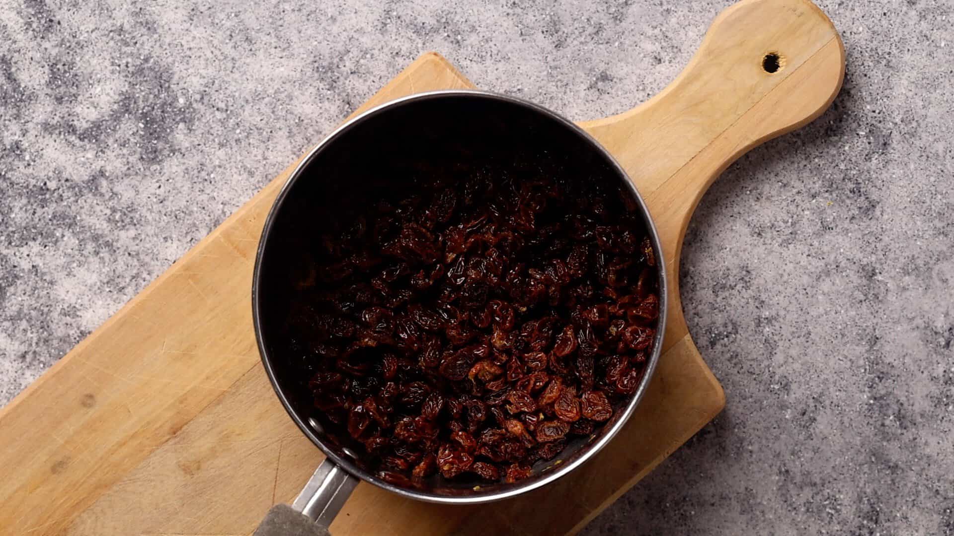 Soaked raisins in a saucepan.