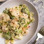 A white pasta bowl filled with shrimp broccoli pasta.