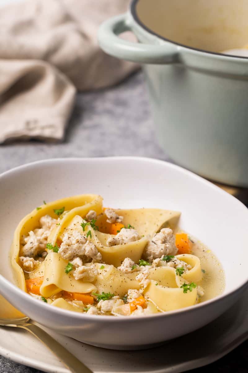 Chicken soup with noodles in bowl.