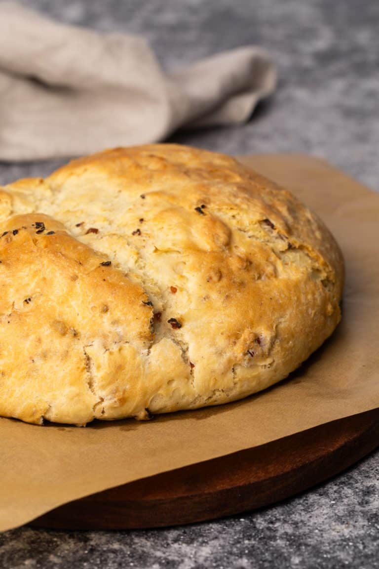 Lard bread on parchment paper next to a linen tea towel.