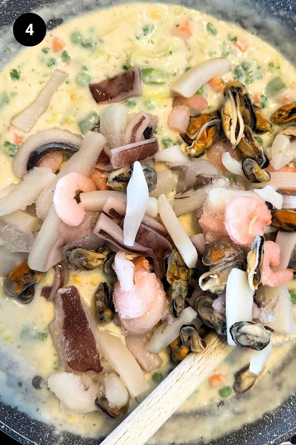 A pan filled with seafood filling, frozen seafood shown.