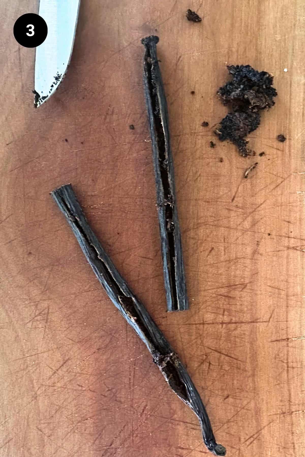 Vanilla scraped out of a pod on a wooden board.
