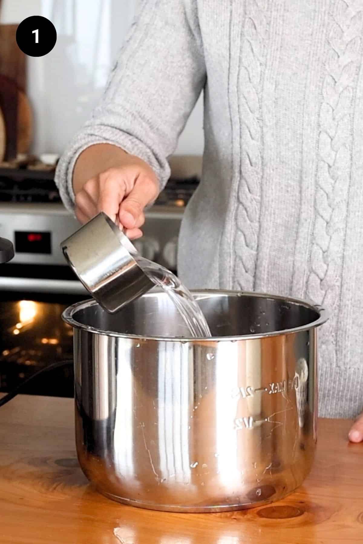 Water being poured into the Instant Pot vessel.