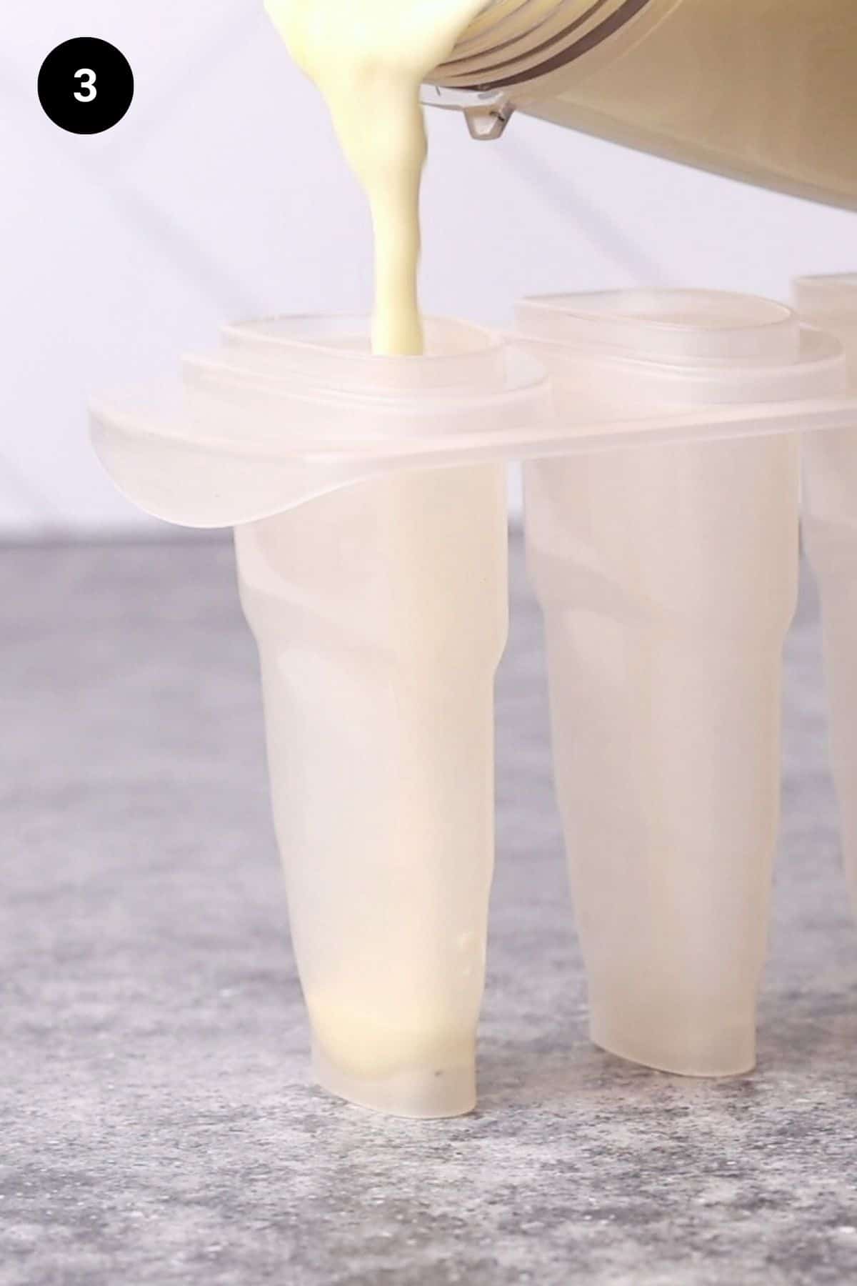 Popsicle mixture being poured into the ice block moulds.