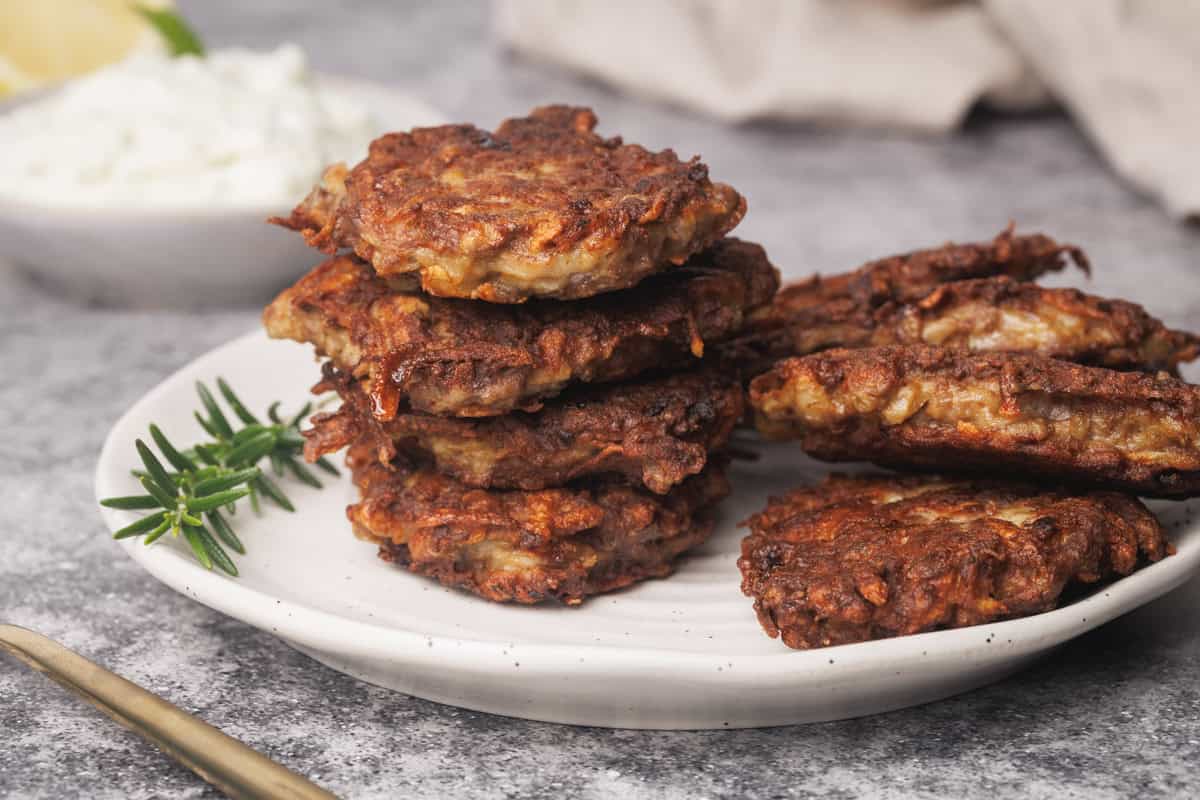 A stack of beef fritters on a white plate.