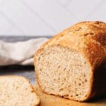 A loaf of cold fermented bread cut open on a wooden board.