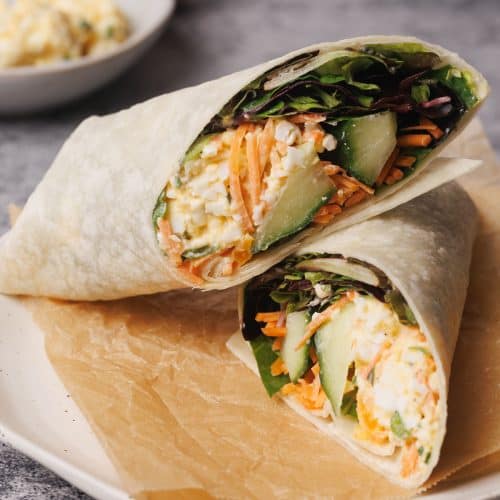 Egg salad wrap on a wooden board.