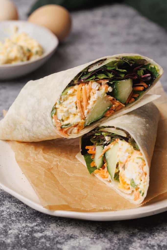 Egg salad wrap on a wooden board.