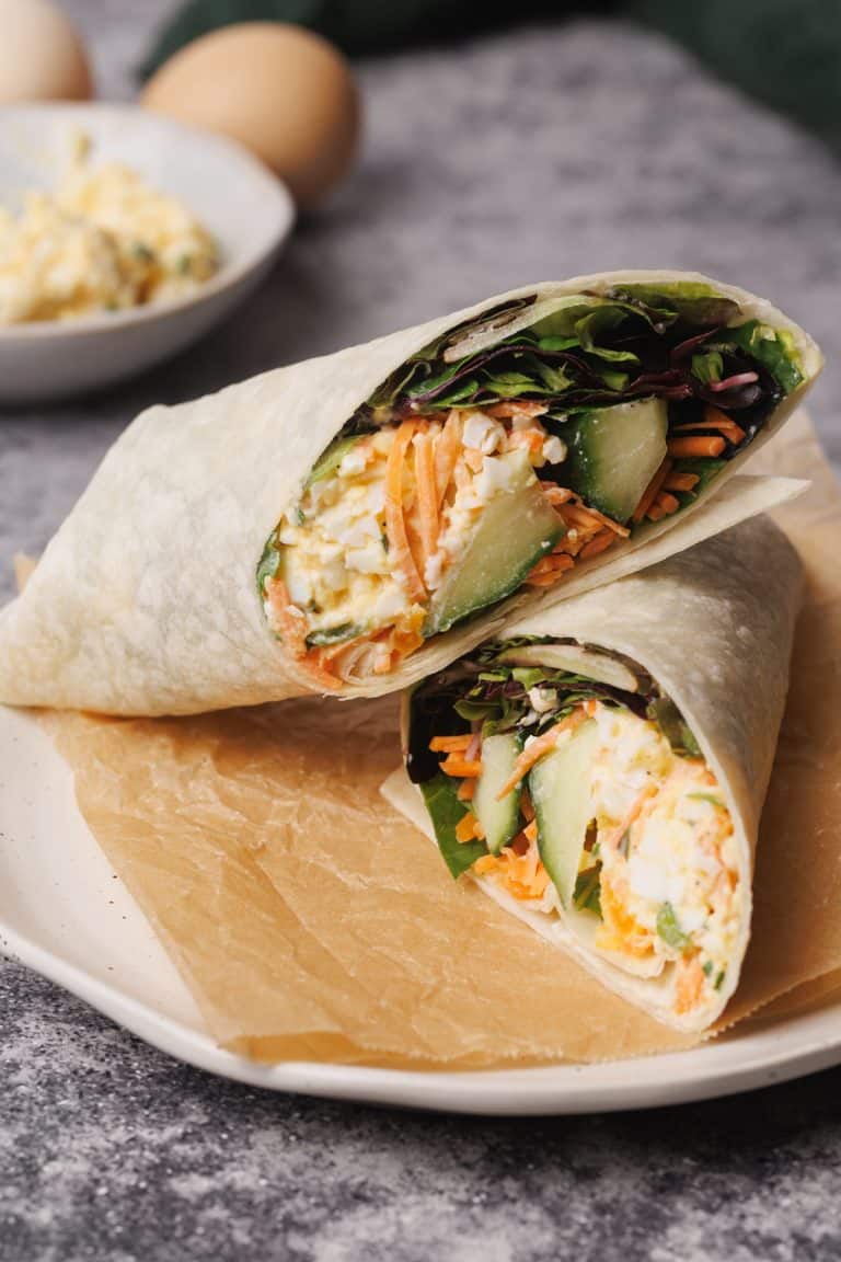 Egg salad wrap on a wooden board.