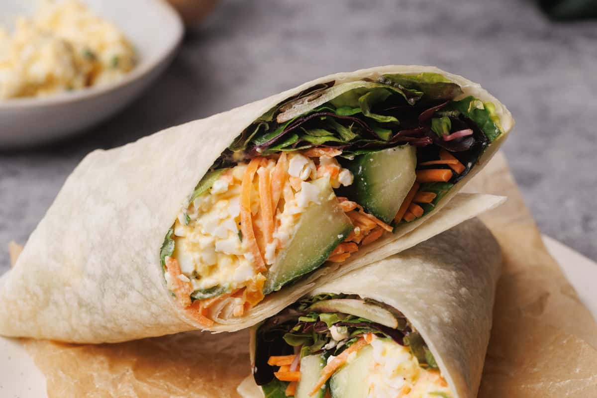 Egg salad wrap on a wooden board.