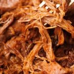 Close-up of the pulled lamb with a golden fork.