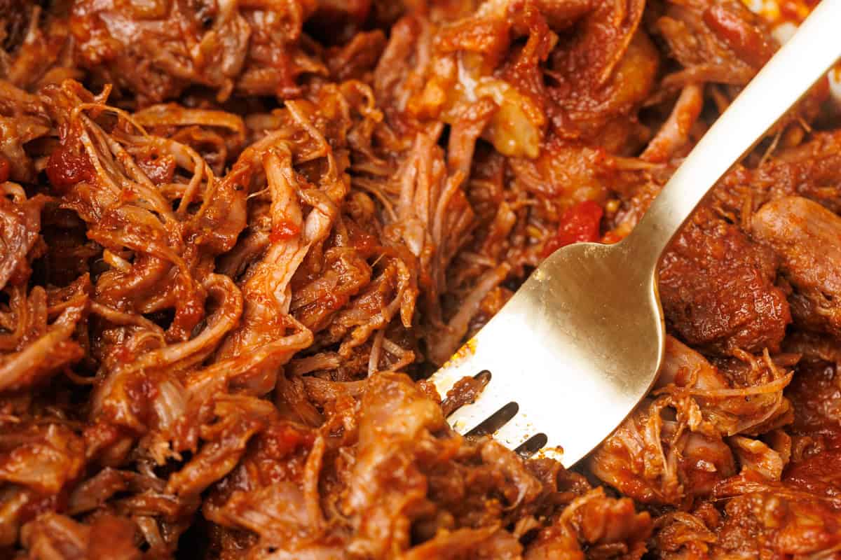 Close-up of the pulled lamb with a golden fork.