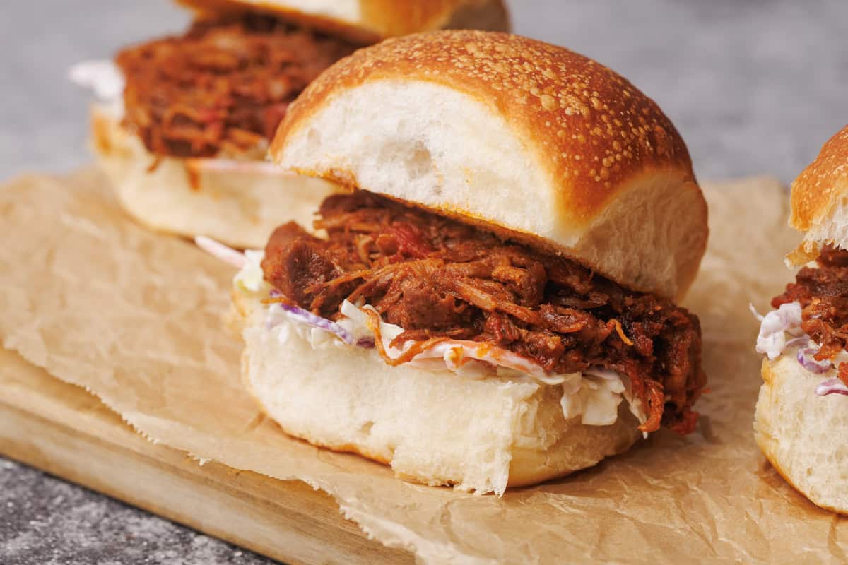 Pulled pork burgers on a wooden board.
