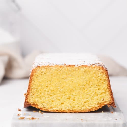 Vanilla pound cake on a marble tray, white background.