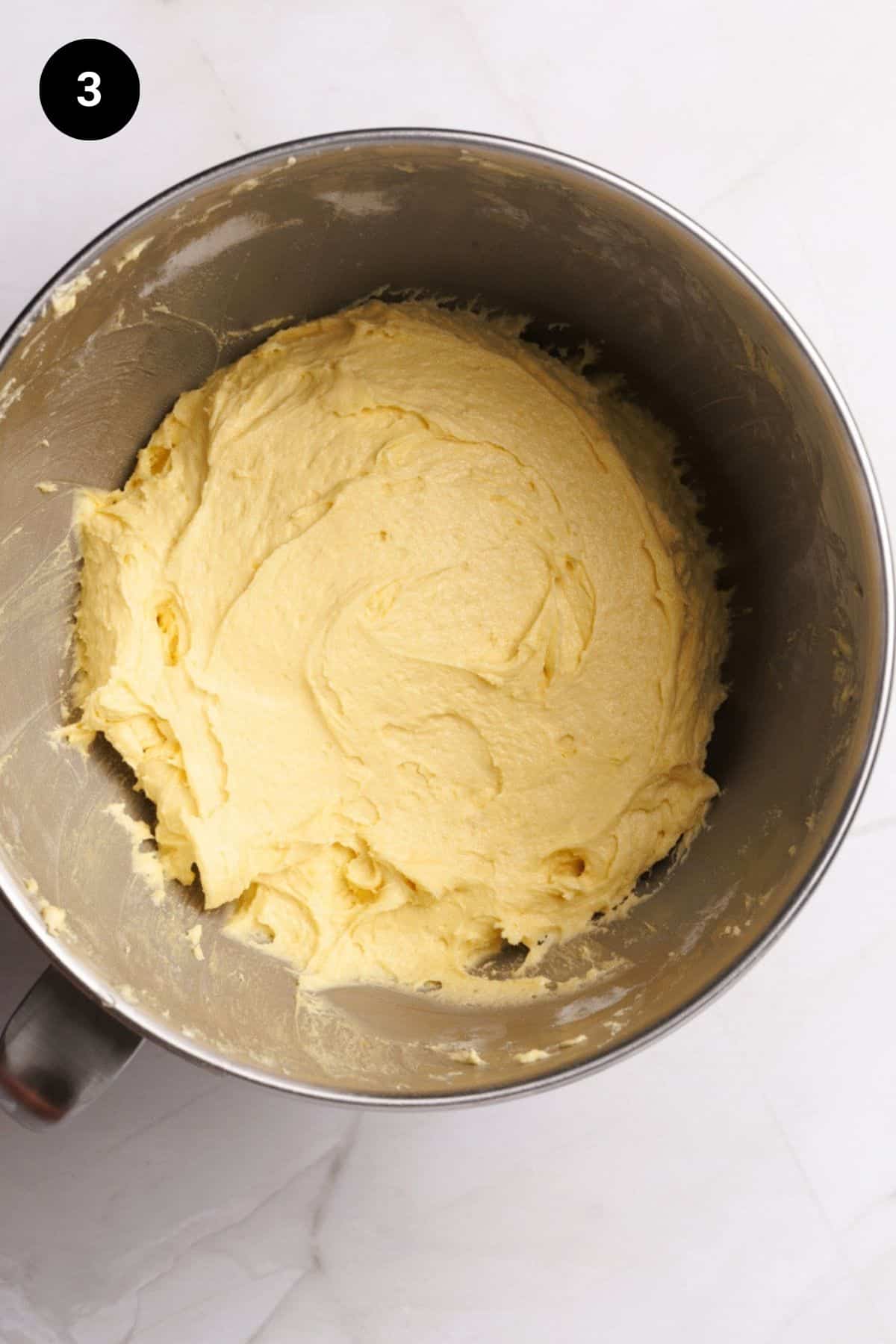 Plain cake batter in a metal bowl.