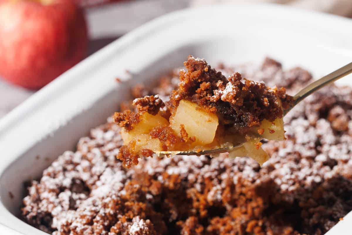 Apple crisp being scooped out of the baking dish.