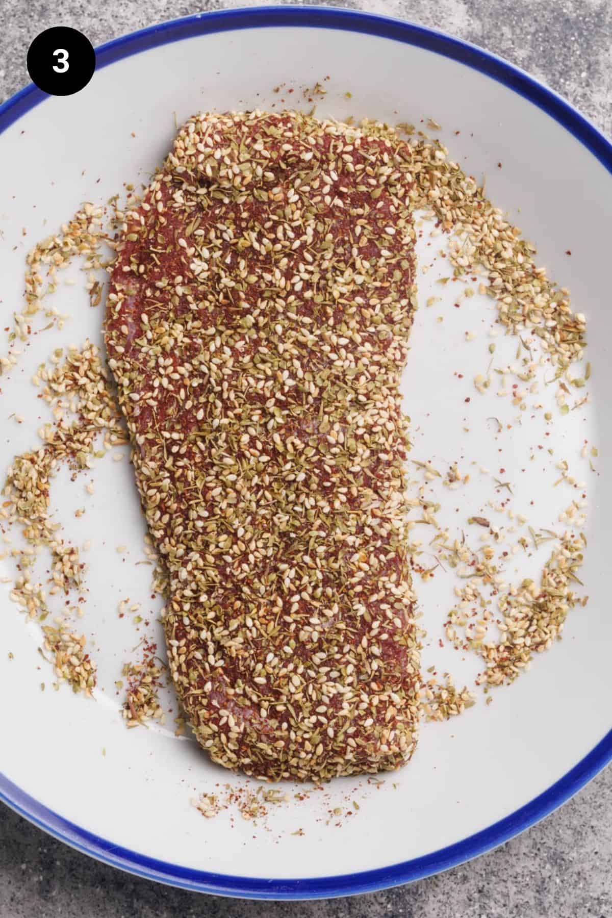 Crusted lamb loin on a white plate.