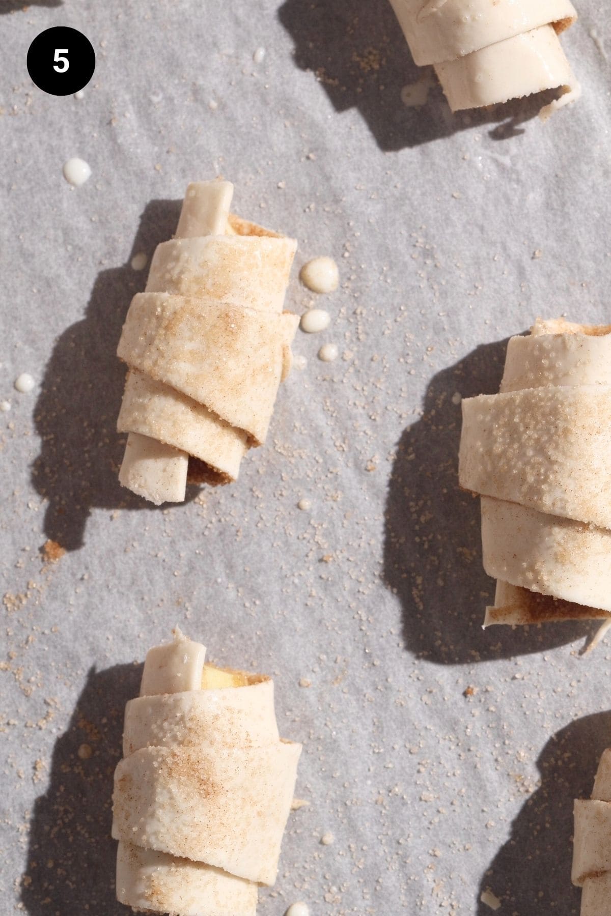 Unbaked apple croissants on a baking tray.