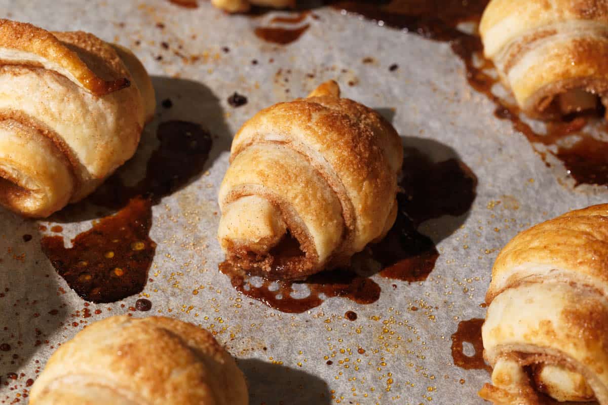 Mini apple croissants on a baking tray.