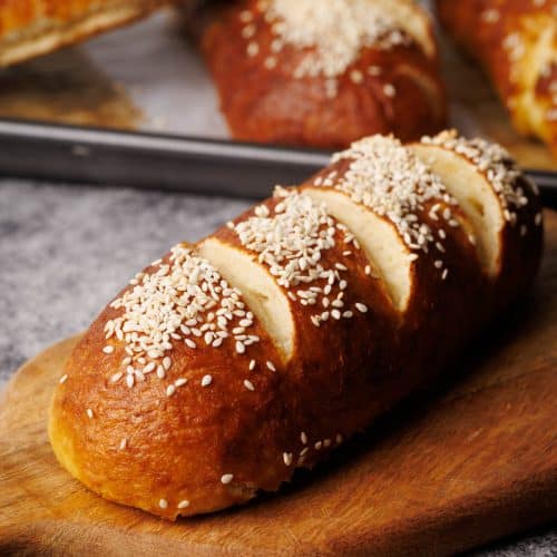 A pretzel bun on a wooden board.