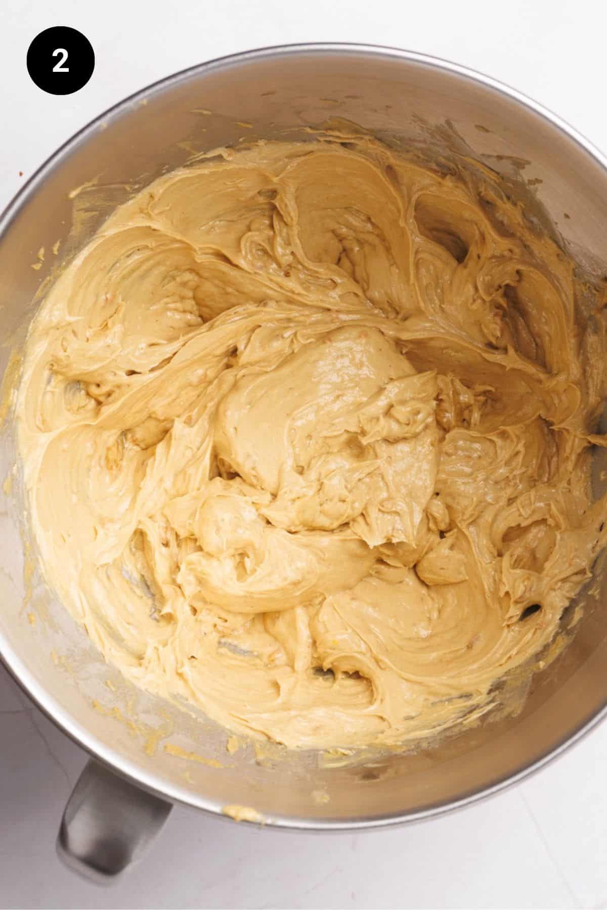 Light and fluffy wet ingredients in a metal bowl.