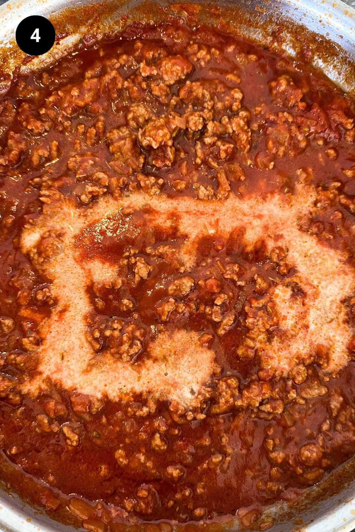 Lamb bolognese in a large metal pan.
