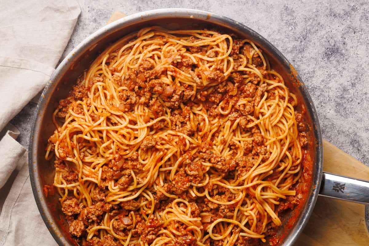 Lamb bolognese in a large metal pan.