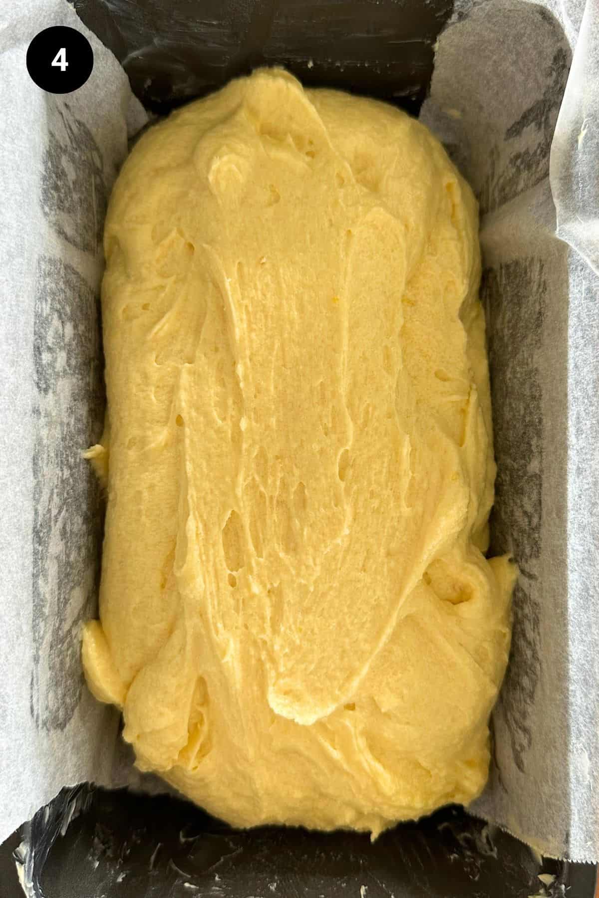 Lemon cake batter in a greased and lined loaf tin.