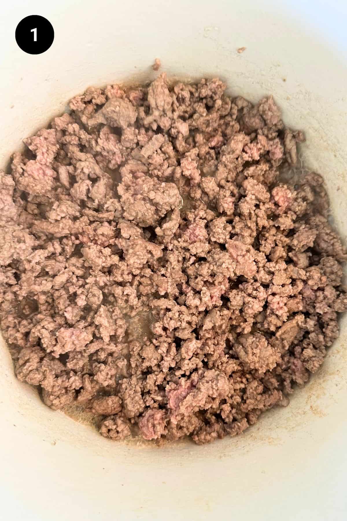 Browned ground lamb in a Dutch oven.