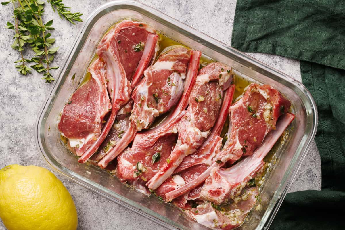 Lamb chops being marinated in a galls bowl.