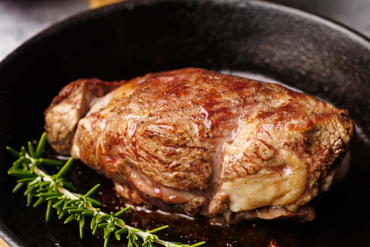 Lamb roast after being cooked in the oven in the cast iron skillet.