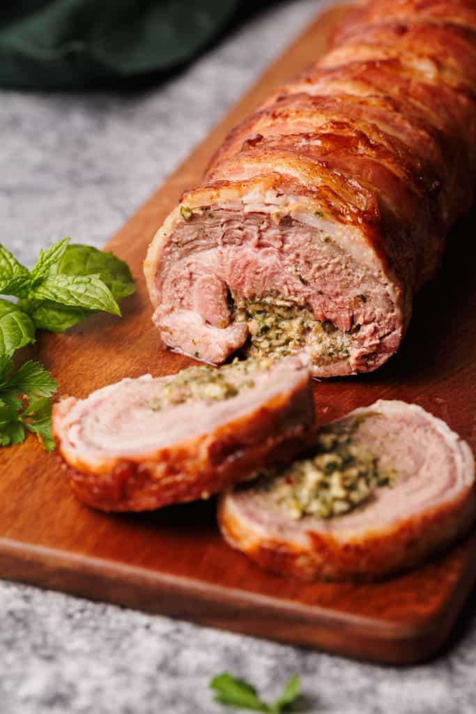 Stuffed lamb leg on a wooden board.