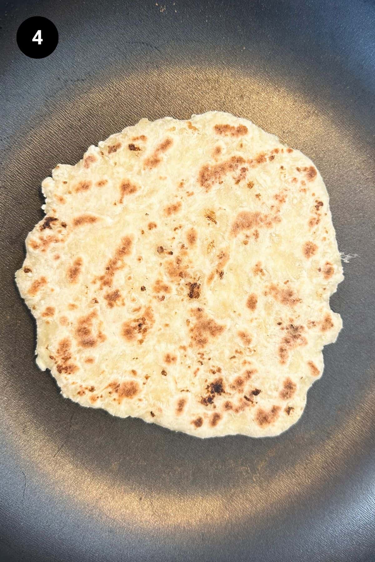Flatbread being baked in a pan.