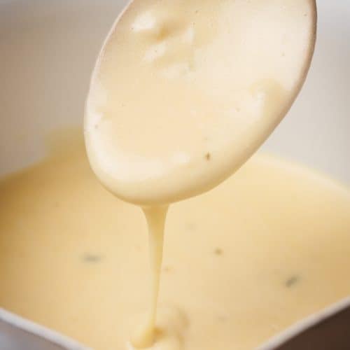 Garlic sauce being drizzled from a spoon.