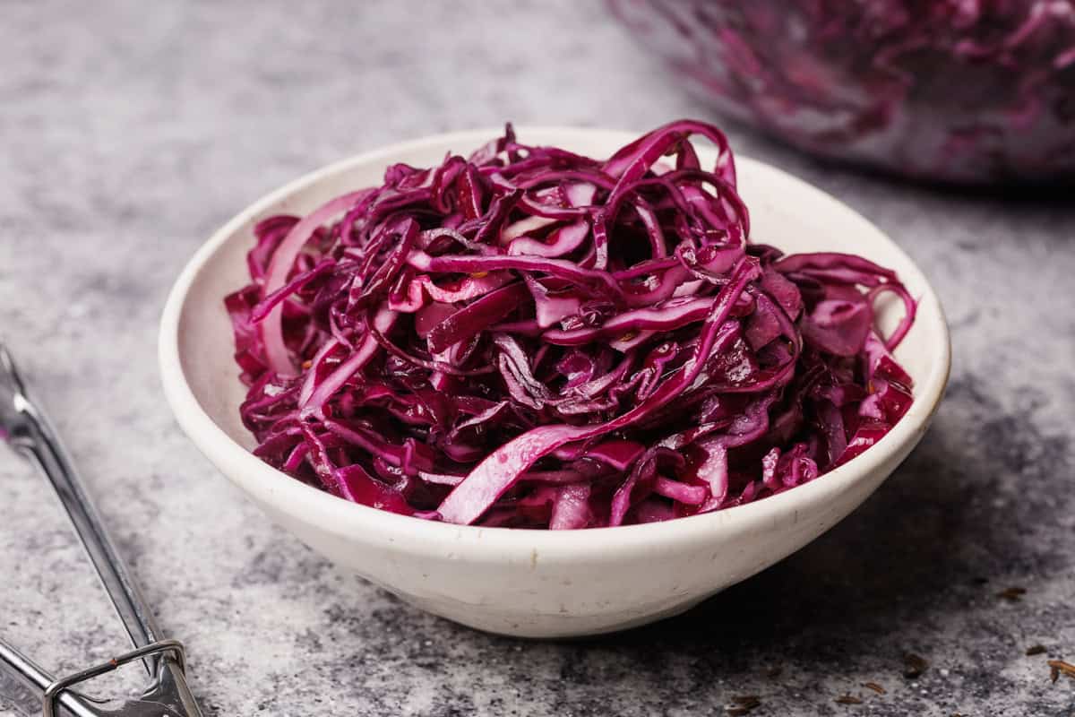 Red cabbage salad in a white bowl.