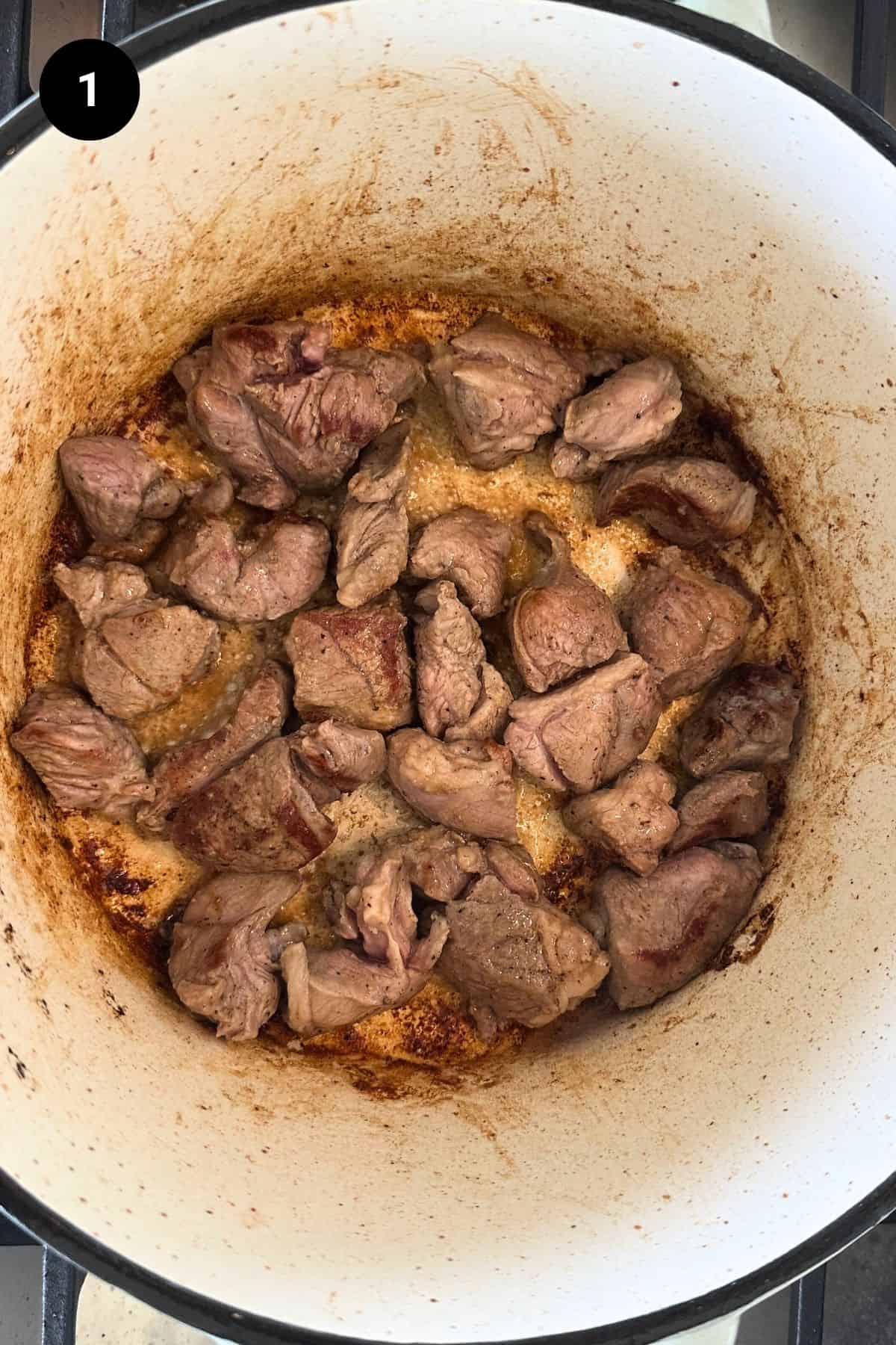 Searing the diced beef in large pot.