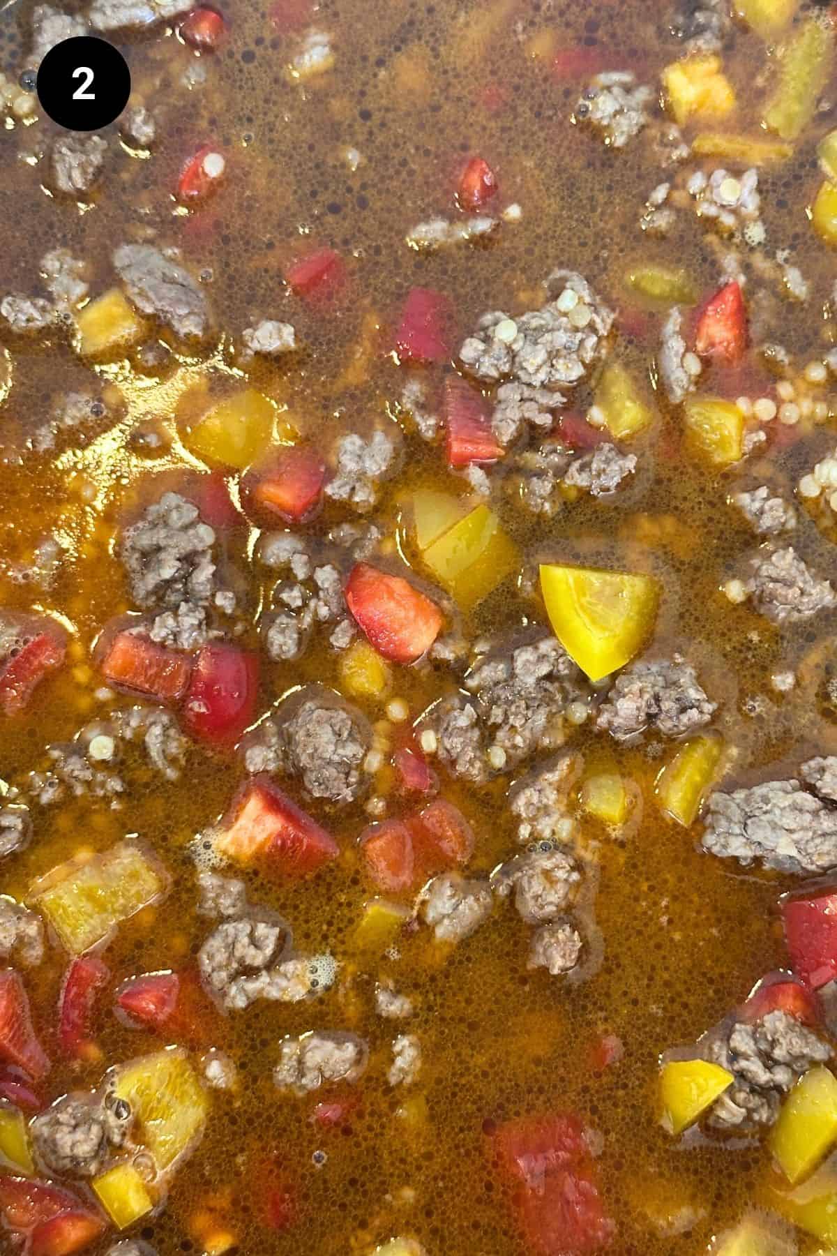 Close-up of lamb and stock cooking.